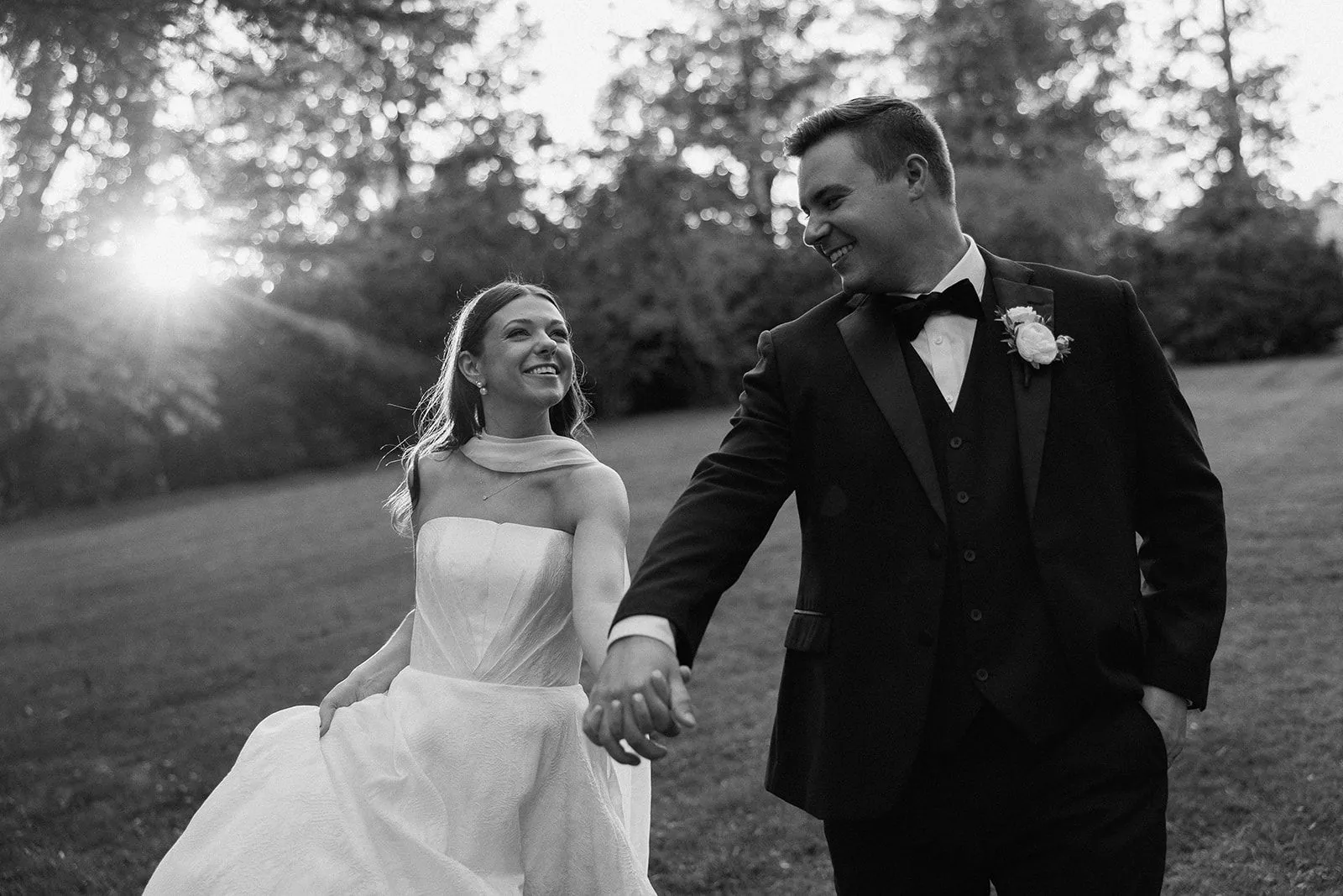 A couple walking hand in hand at sunset after their wedding ceremony