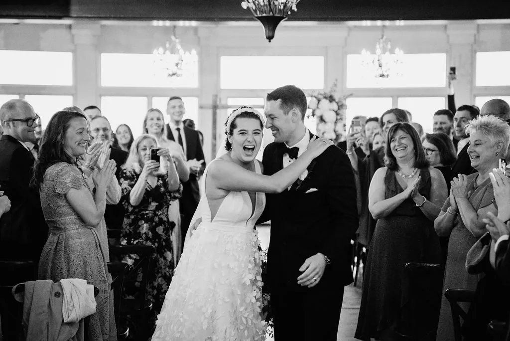 Guests crowding the dance floor around a newly married couple